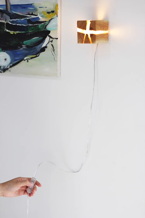 Wandleuchte aus rissigem Massivholz